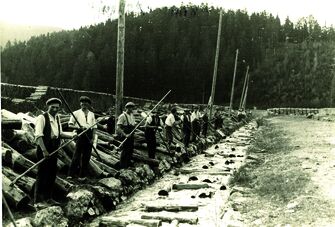 Zahlreiche Holzschwemmer bei der Arbeit. Schwarzweißfoto. (Vergrößerte Ansicht)