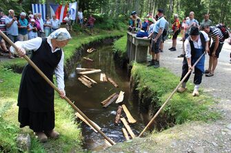 Holzschwemmerin in traditioneller Kleidung bei der Arbeit. (Vergrößerte Ansicht)